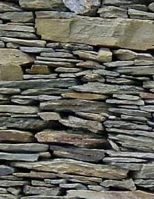 Detall d'una paret amb pedres horitzontals.